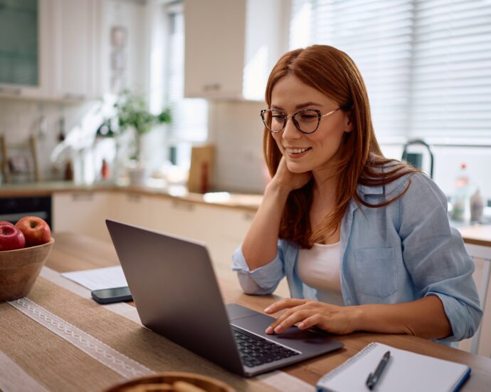 Happy woman working on laptop at home.
