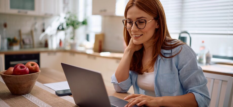 Happy woman working on laptop at home.