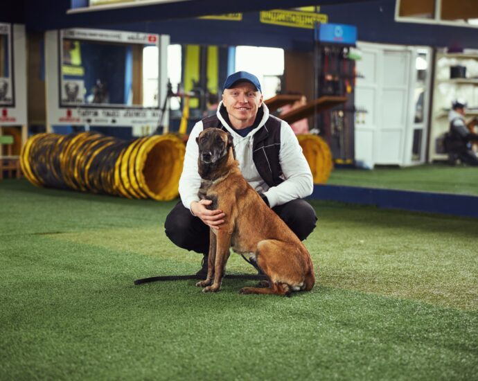 Instructor posing for the camera with a calm adult dog