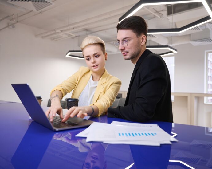 Man and woman developing software on laptop