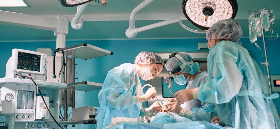 Modern surgery in a technologically advanced hospital. Bright room of intensive care. Doctors and