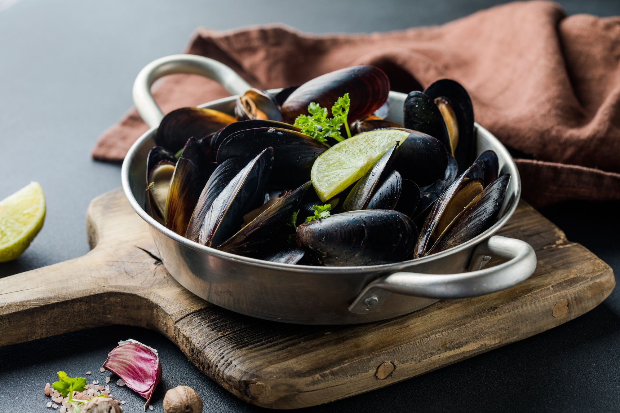 Seafood. Shellfish mussels. Baked mussels on cast iron black plate